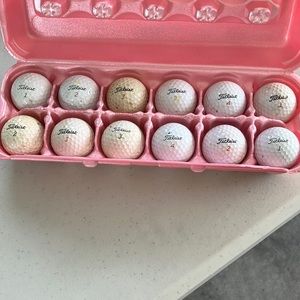 12 used Titleist golf balls.